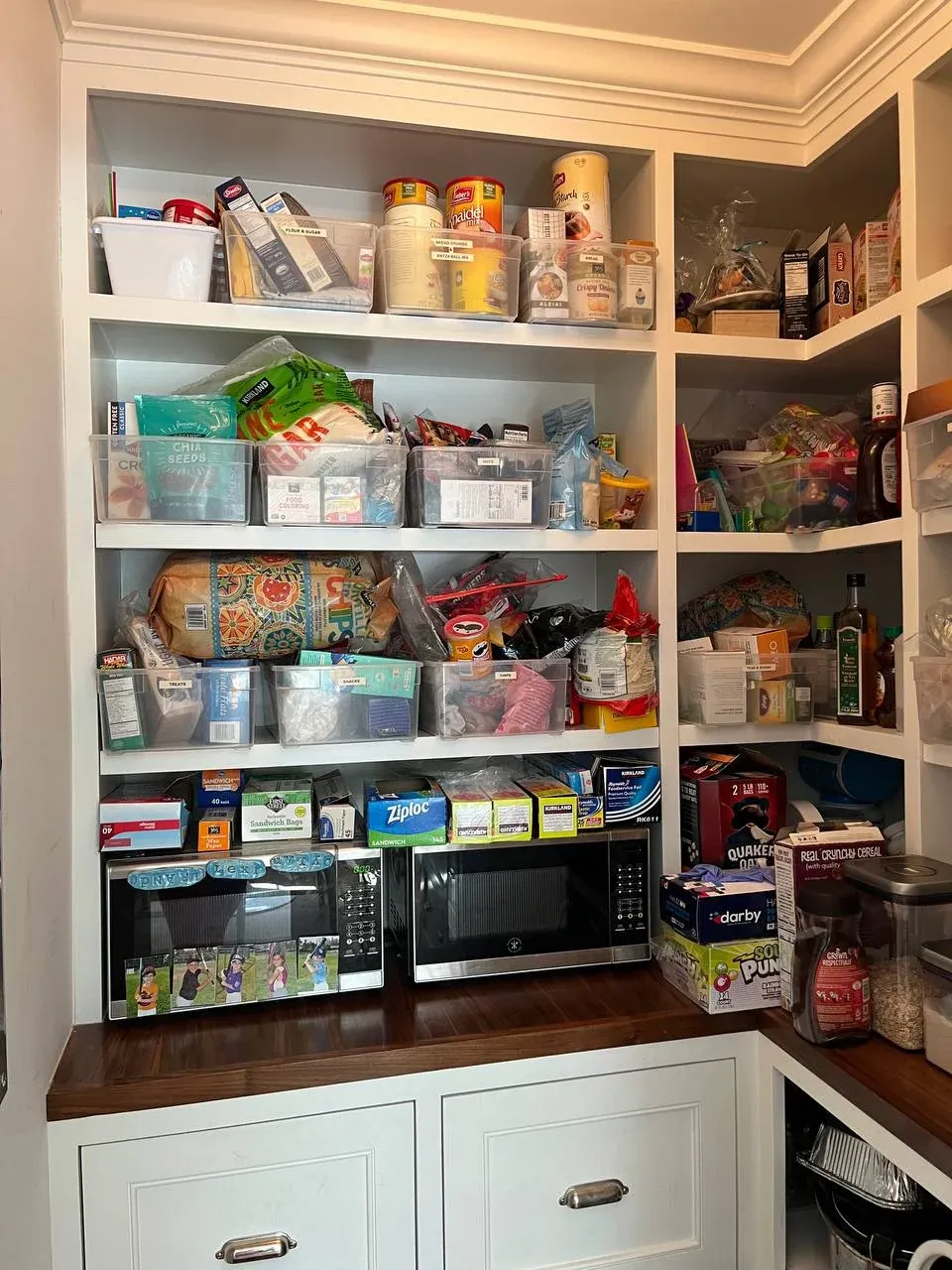 Pantry wall before, shelves crowded with boxed snacks, plastic bins, and loose packaging stacked without a pattern