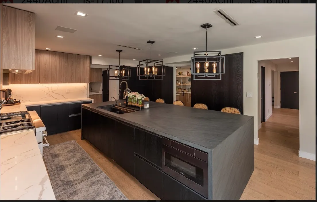 Kitchen with a long island, dark cabinetry, and warm wood ceiling beams