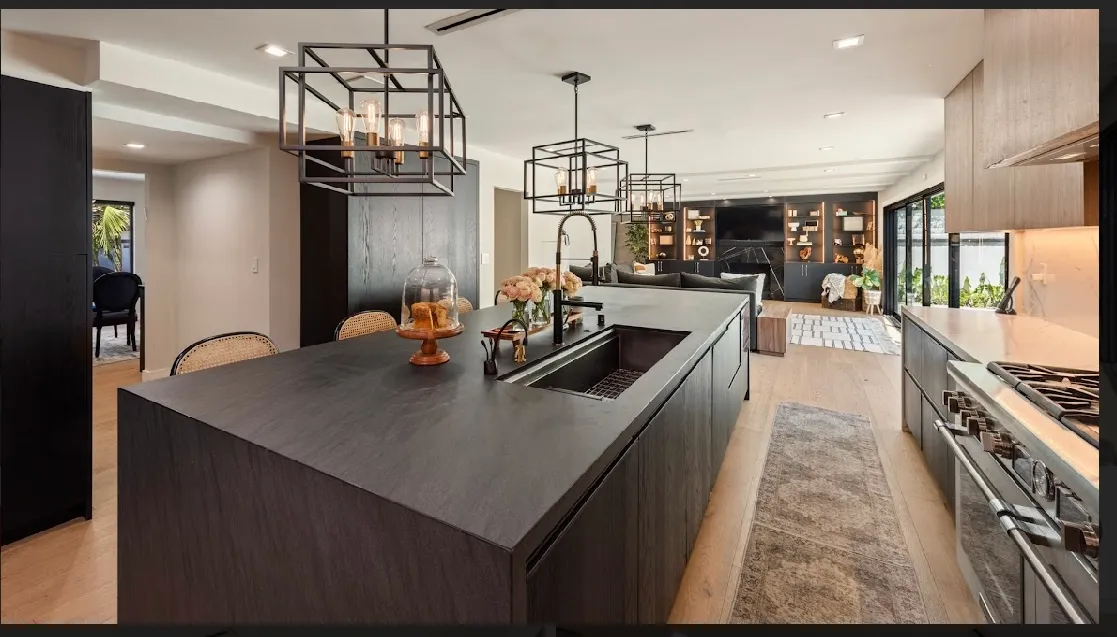 Wide kitchen view with the island, range, and pantry entry visible at the back