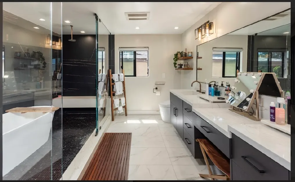 Primary bathroom with double vanity, walk-in shower, and a soaking tub beyond